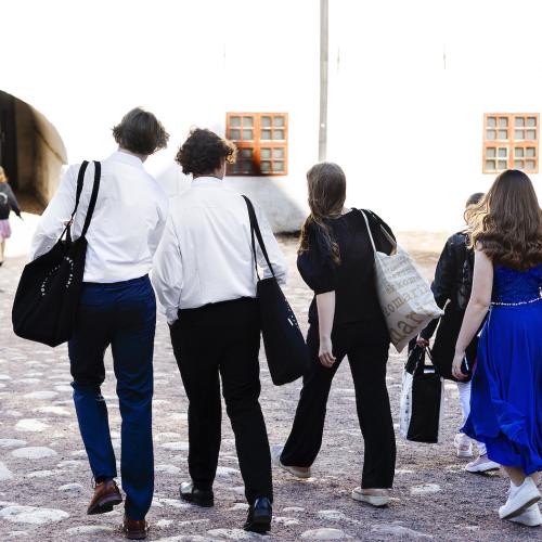 A group of students walking on the street away from the camera.